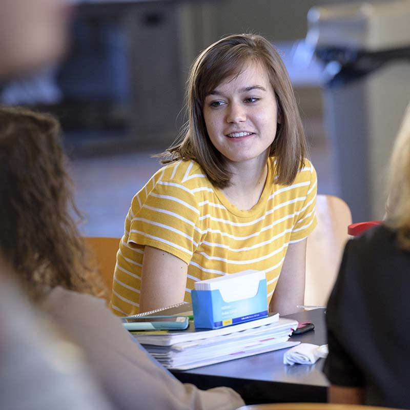 Girl smiling while talking to other students