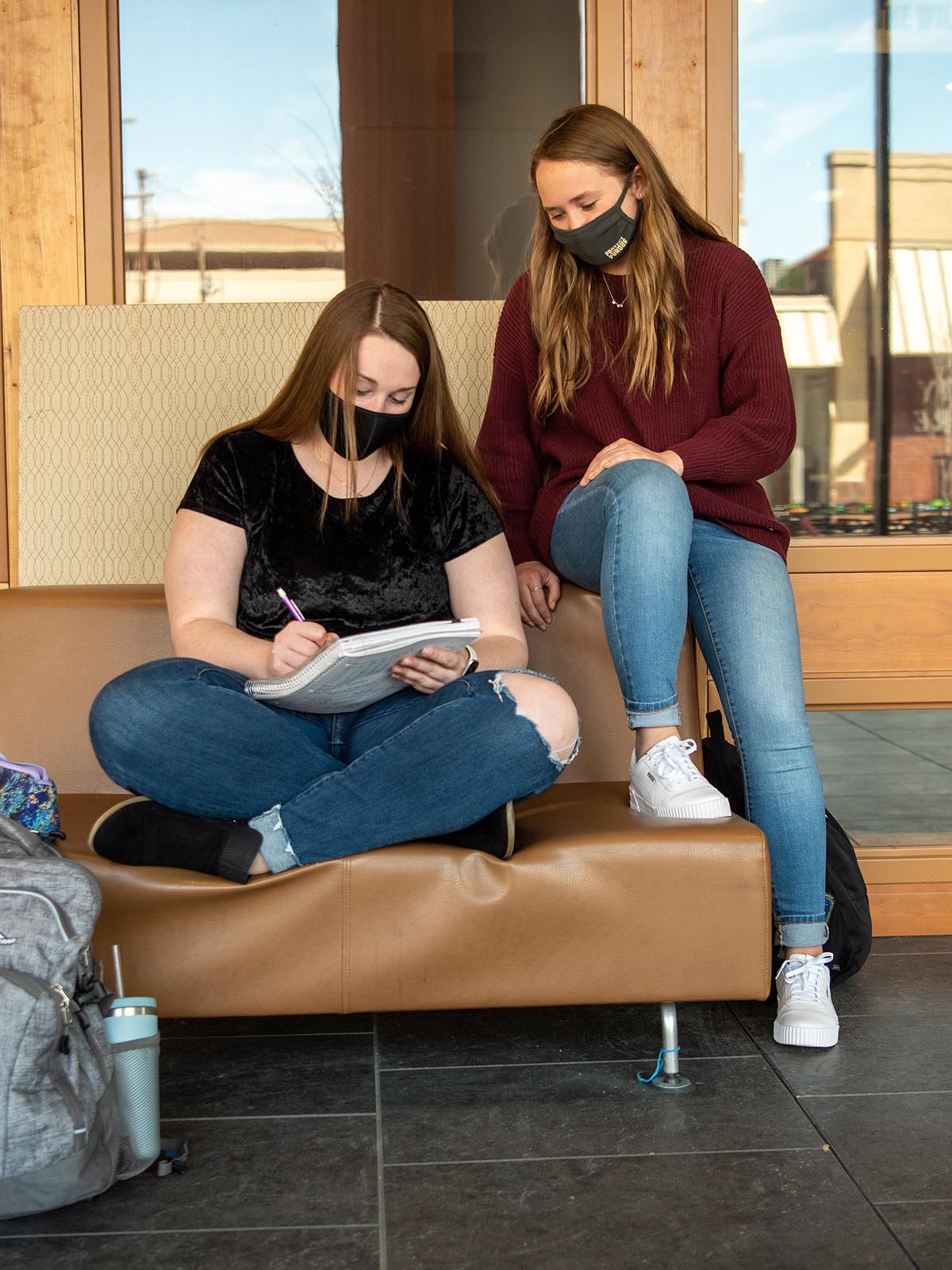 Two students look over class notes in the Rawls lobby